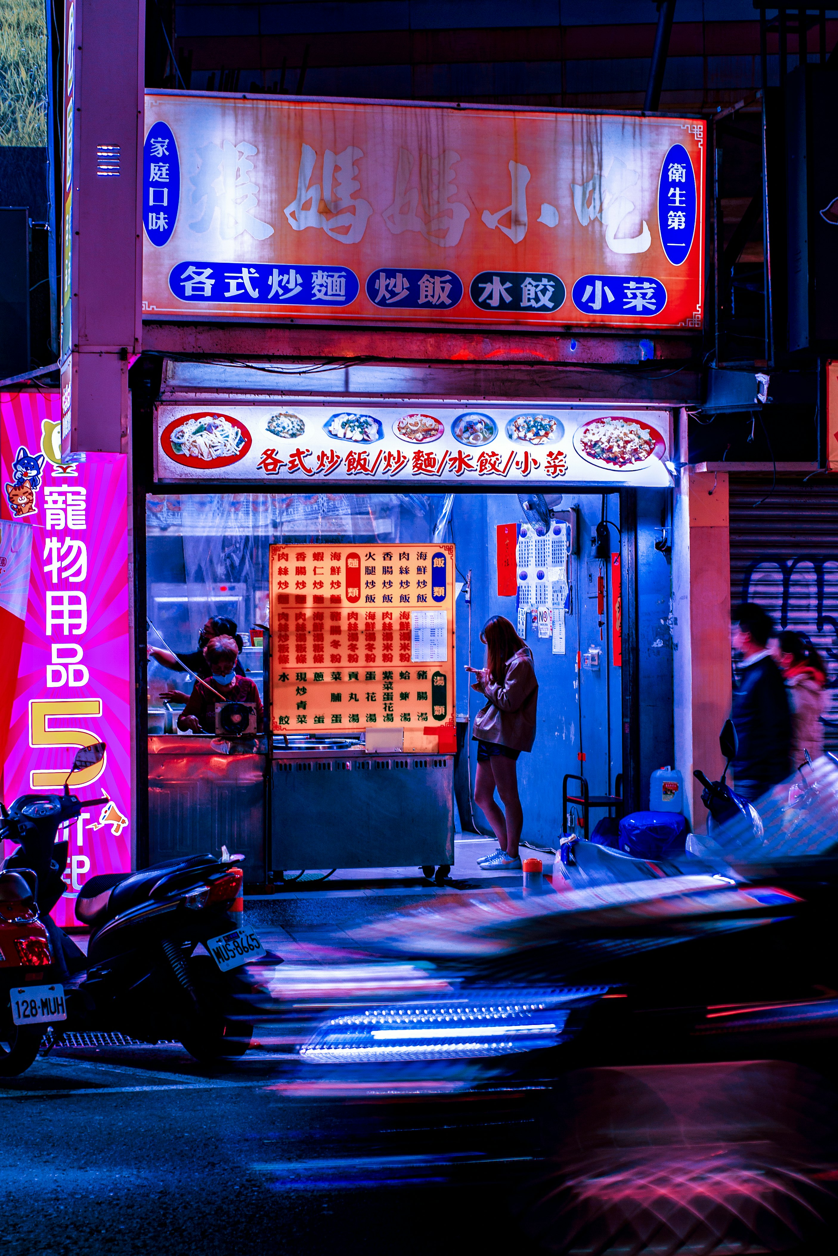 woman in black tank top standing near store during night time